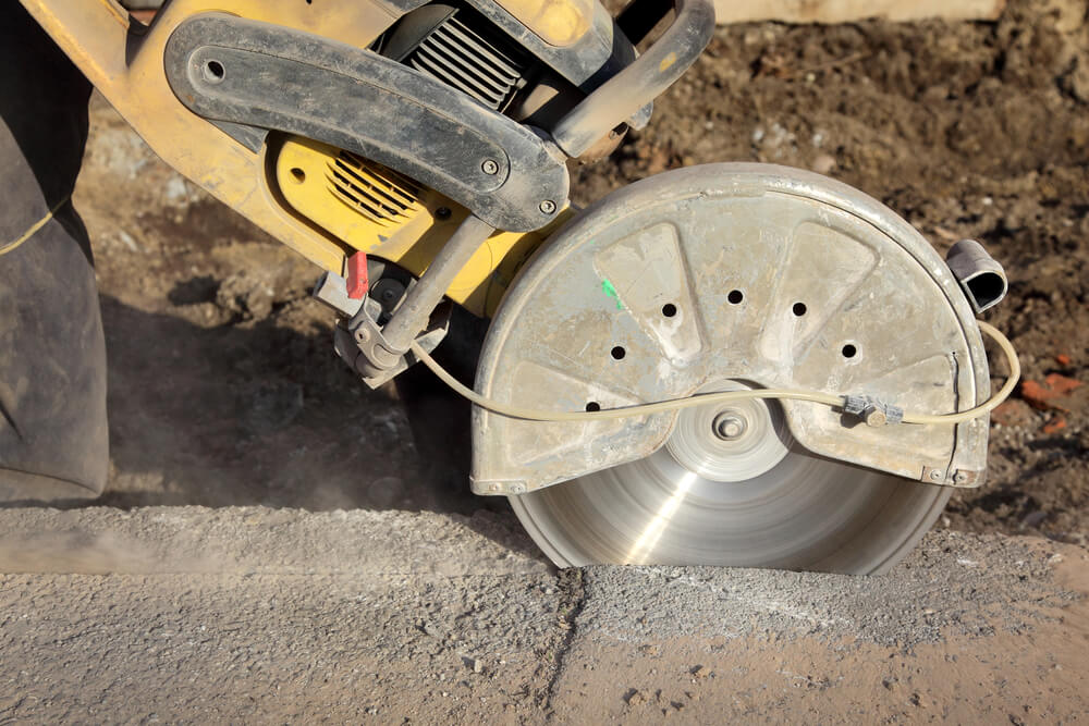 image of a concrete cutting saw mid way through cutting some concrete