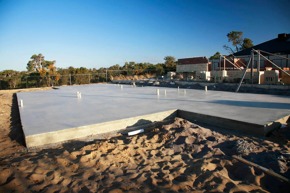 outdoor view of a finished concrete slab surrounded by sand 