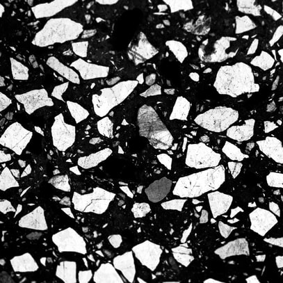 Close up view of black polished concrete with white stones that has been polished