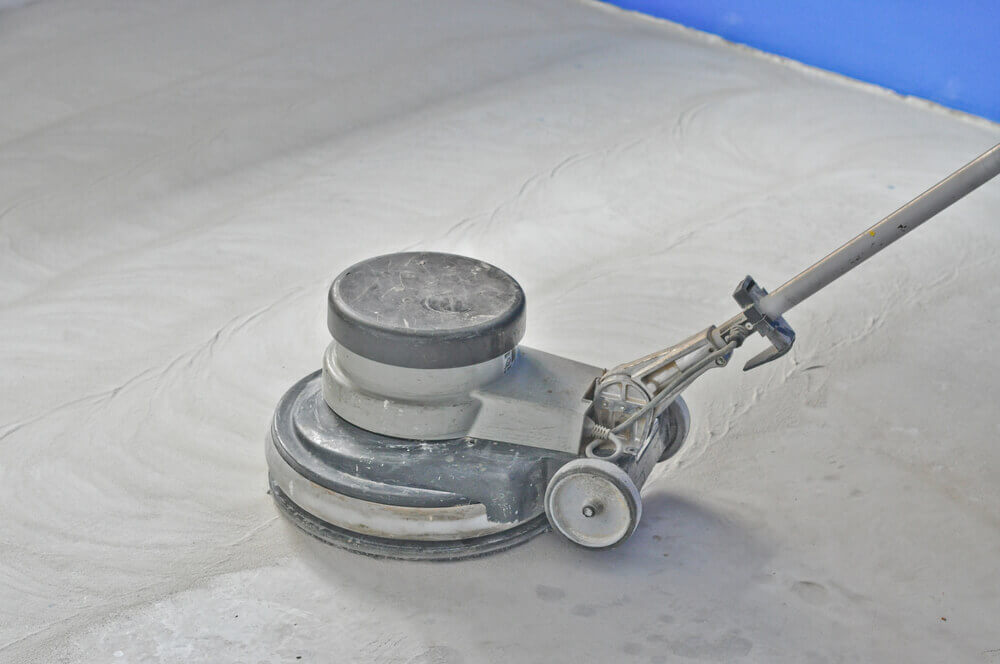 Image of a polished concrete machine sitting in a room that has been half sanded already